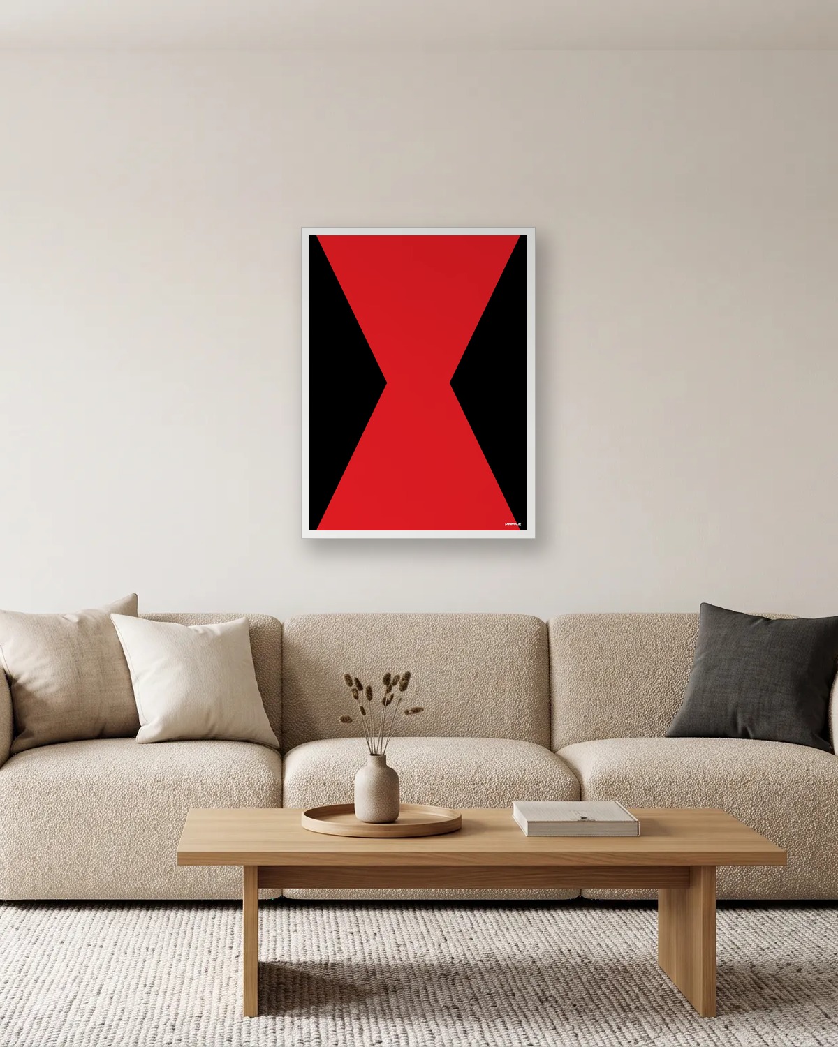 Affiche rouge et noire minimaliste encadrée en blanc au-dessus d'un canapé beige : un sablier rouge sur fond noir